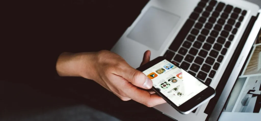 Encontre um aplicativo para criar logotipos: a imagem mostra um celular com a tela cheia de opções de aplicativos, ideal para descobrir as melhores opções gratuitas.